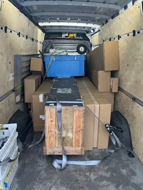 Vue intérieure d'une camionnette de transport express chargée de colis et de marchandises sécurisées.